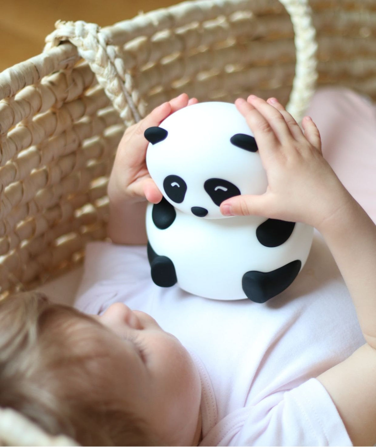 1. Child holding Rabbit & Friends panda silicone lamp in a woven basket setting