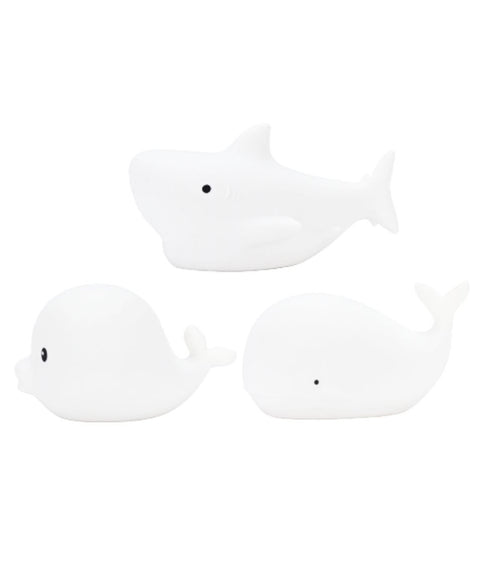 4. Flat lay of three white silicone marine lamps, Dolphin, Whale, and Shark, showing simple design