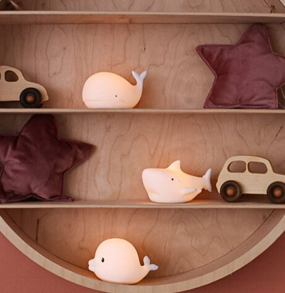 5. Three glowing marine lamps, Dolphin, Whale, and Shark, on a wooden shelf with decorative items