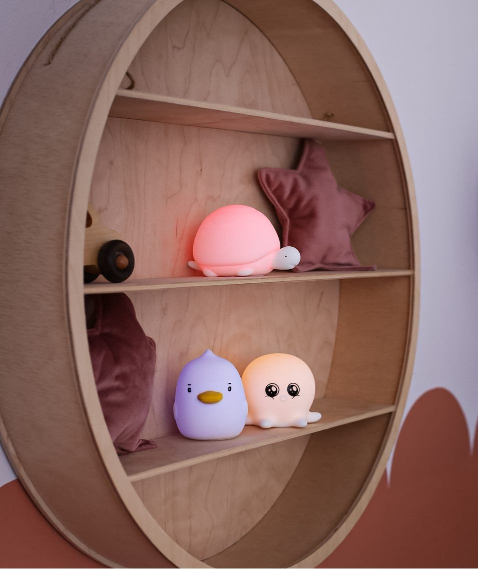 4. Duck, octopus, and turtle shaped lamps on wooden shelf in child's room