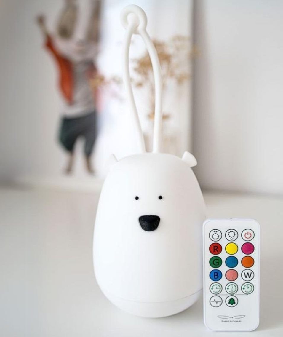 7. White bear-shaped night light with remote control on a table with a blurred background
