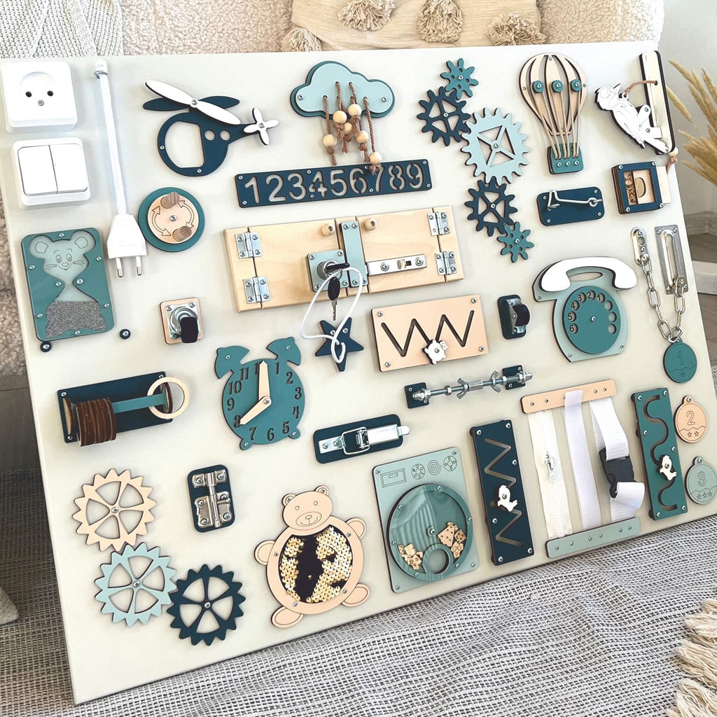 3. Close-up of Montessori busy board with blue and beige elements, highlighting interactive features for sensory play, set against a soft fabric background.