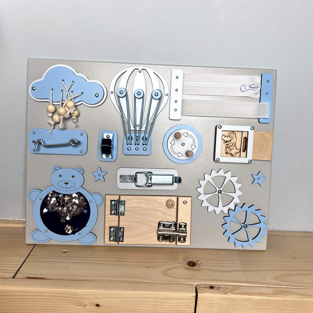 2. BusyBunnyToys busy board with blue accents and various interactive elements, displayed on a wooden background