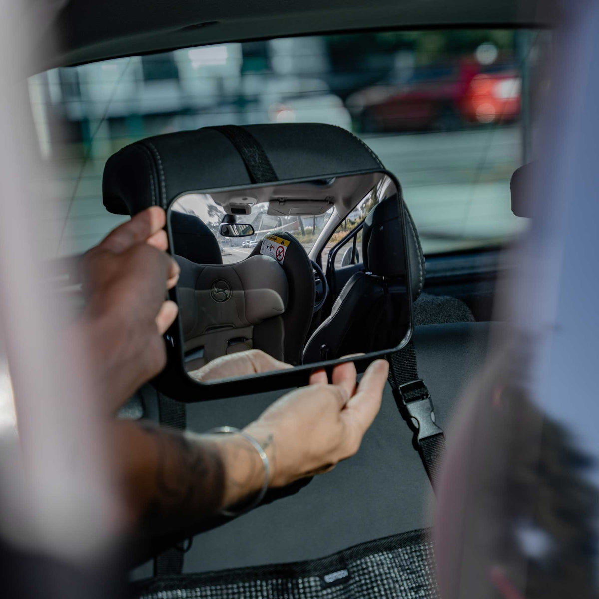 8. Hands adjusting Ezimoov EZI MIRROR CLASSIC on rear headrest for optimal view