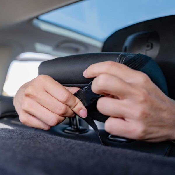 4. Hands adjusting Ezimoov EZI MIRROR LED strap on car headrest for secure fit