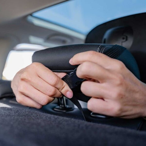 4. Hands adjusting Ezimoov EZI MIRROR LED strap on car headrest for secure fit