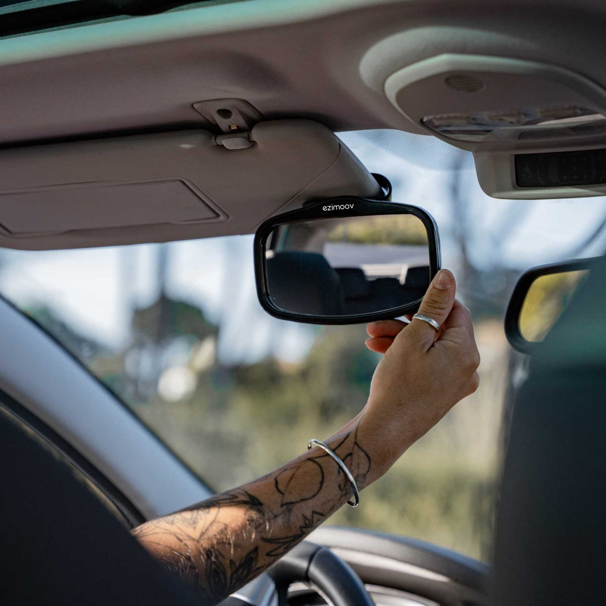 11. Person installing Ezimoov EZI MIRROR MINI on car sun visor