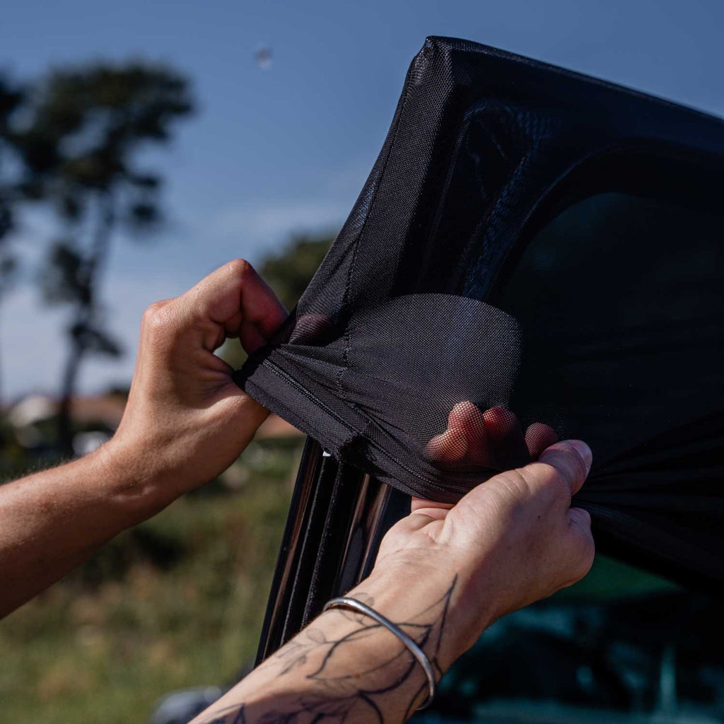 6. Hands stretching Ezimoov EZI SUN SOCKS over car window in sunny environment