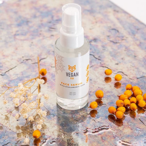 2. Vegan Fox Face Serum with Hyaluronic Acid, 30 ml, surrounded by sea buckthorn berries on a textured surface