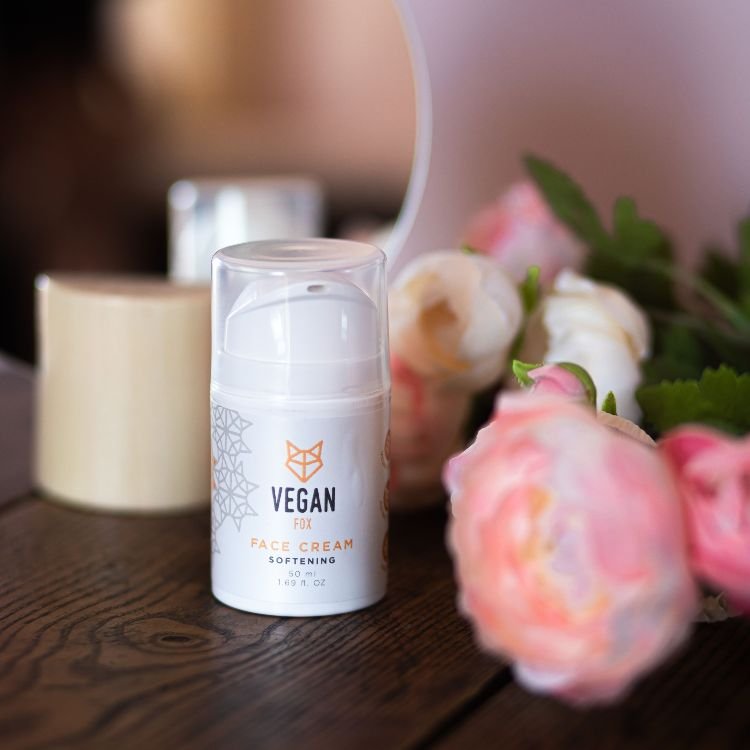 2. Vegan Fox Softening Face Cream on a wooden table with pink flowers, showcasing elegant packaging