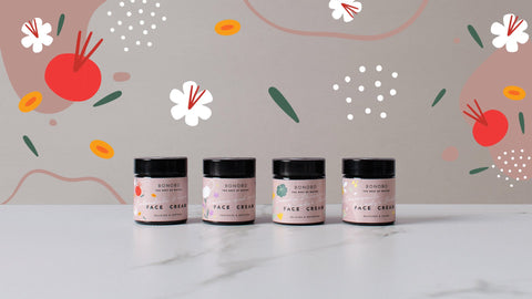 2. BONOBO face cream collection on marble surface with colorful floral background, featuring Calendula & Rosehip variant