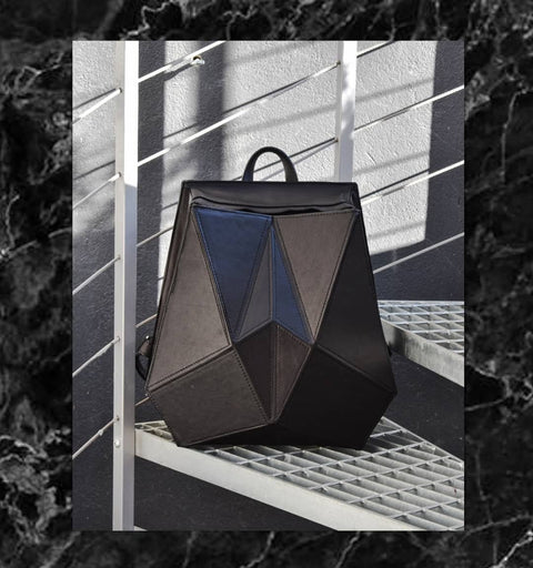 3. Gerda Retter Design FACET black leather backpack displayed on metal stairs, highlighting geometric design