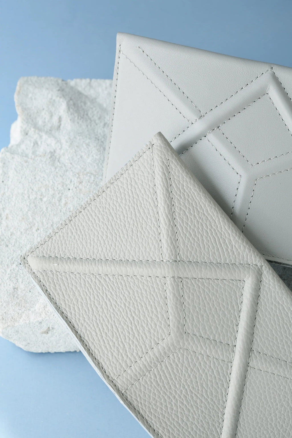 2. Studio shot of two Gerda Retter Design FACET Clutches in light grey, highlighting geometric design on textured leather