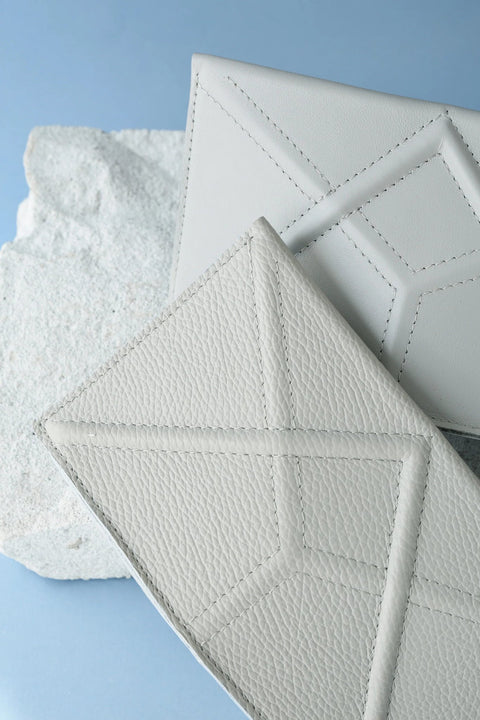 2. Studio shot of two Gerda Retter Design FACET Clutches in light grey, highlighting geometric design on textured leather