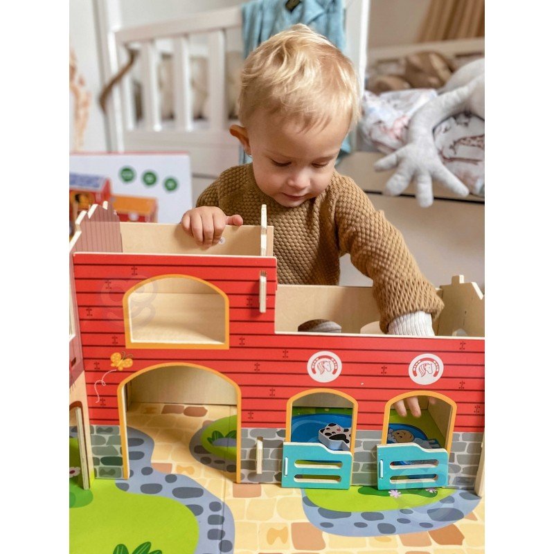 1. Child interacting with Woopie Green Mega Farm set, featuring barn and animal figurines in a nursery setting