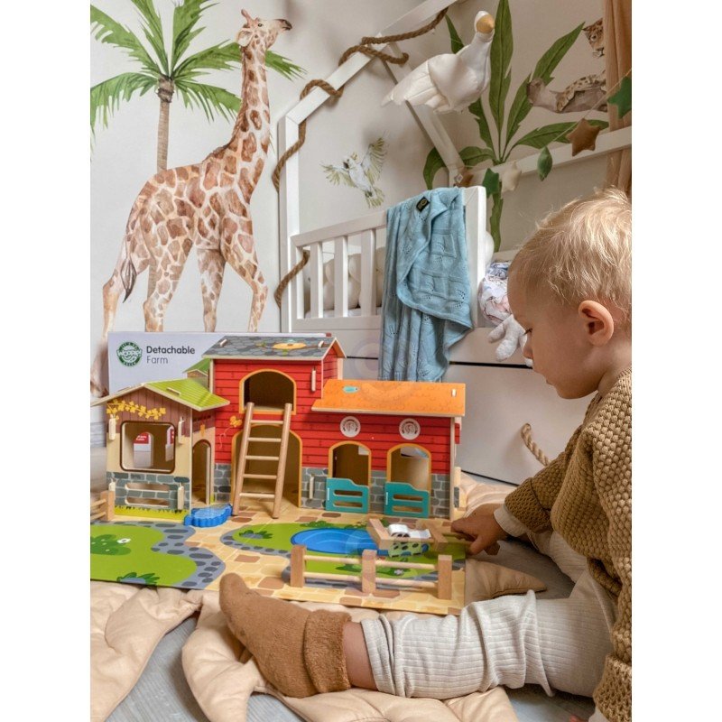 1. Child engaging with Woopie Green Mega Farm set, featuring barn and animal figurines in a jungle-themed room