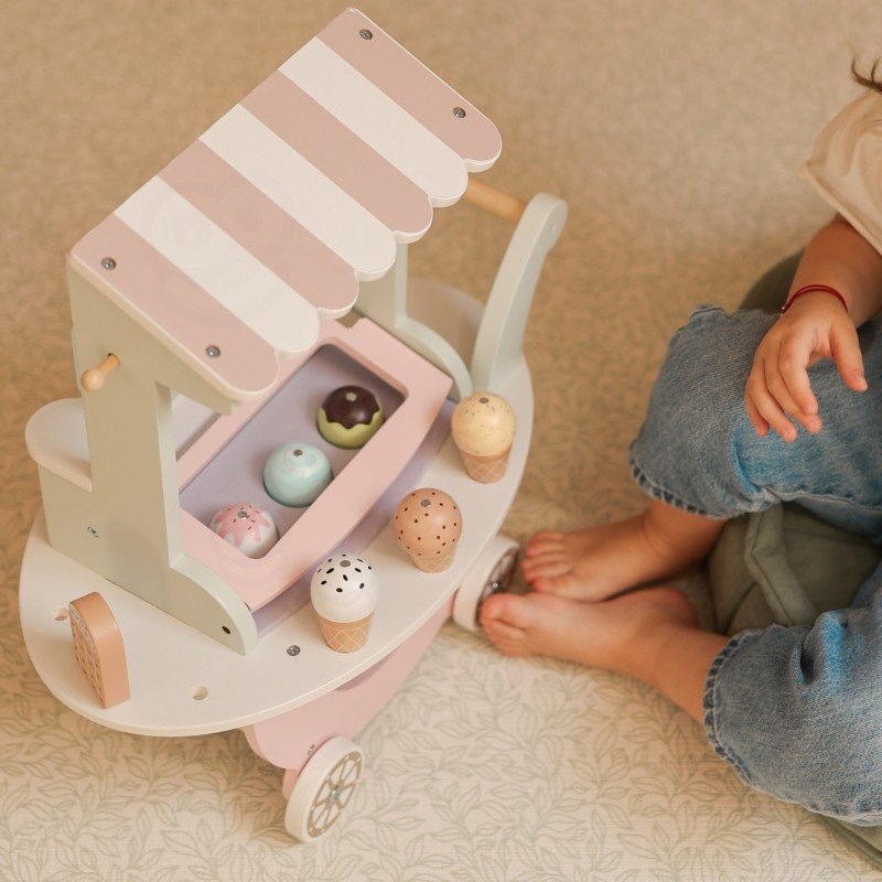 3. Top view of pastel wooden ice cream cart with magnetic scoops and cones, child sitting nearby