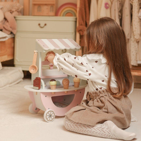 1. Child kneeling and playing with pastel wooden ice cream cart in a cozy playroom