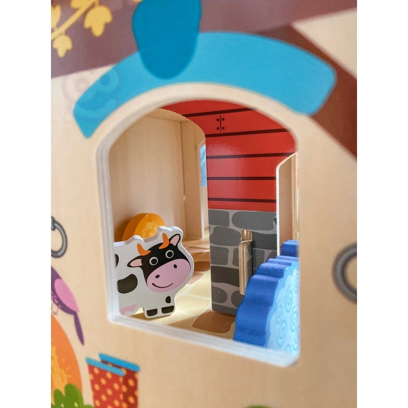 3. Close-up of cow figurine inside Woopie Green Mega Farm set barn, viewed through window