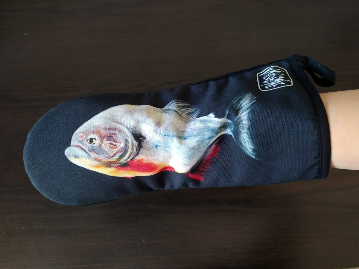 5. Black oven mitt with fish painting, worn on hand, showcasing detailed artwork and brand logo
