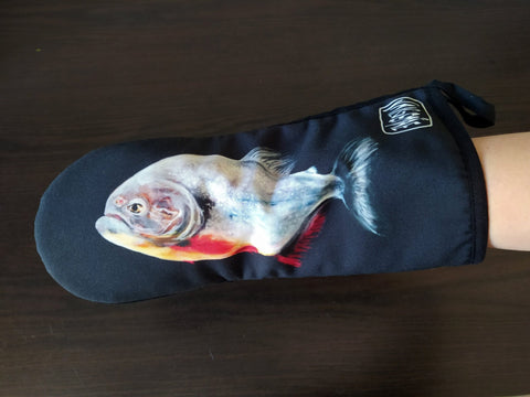 5. Black oven mitt with fish painting, worn on hand, showcasing detailed artwork and brand logo