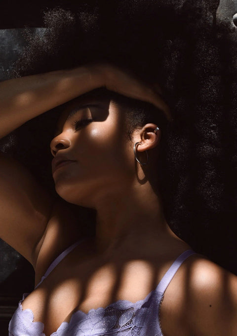 4. Woman wearing NO MORE Flat Upper Ear Cuff in silver, shown in a shadowed lifestyle setting