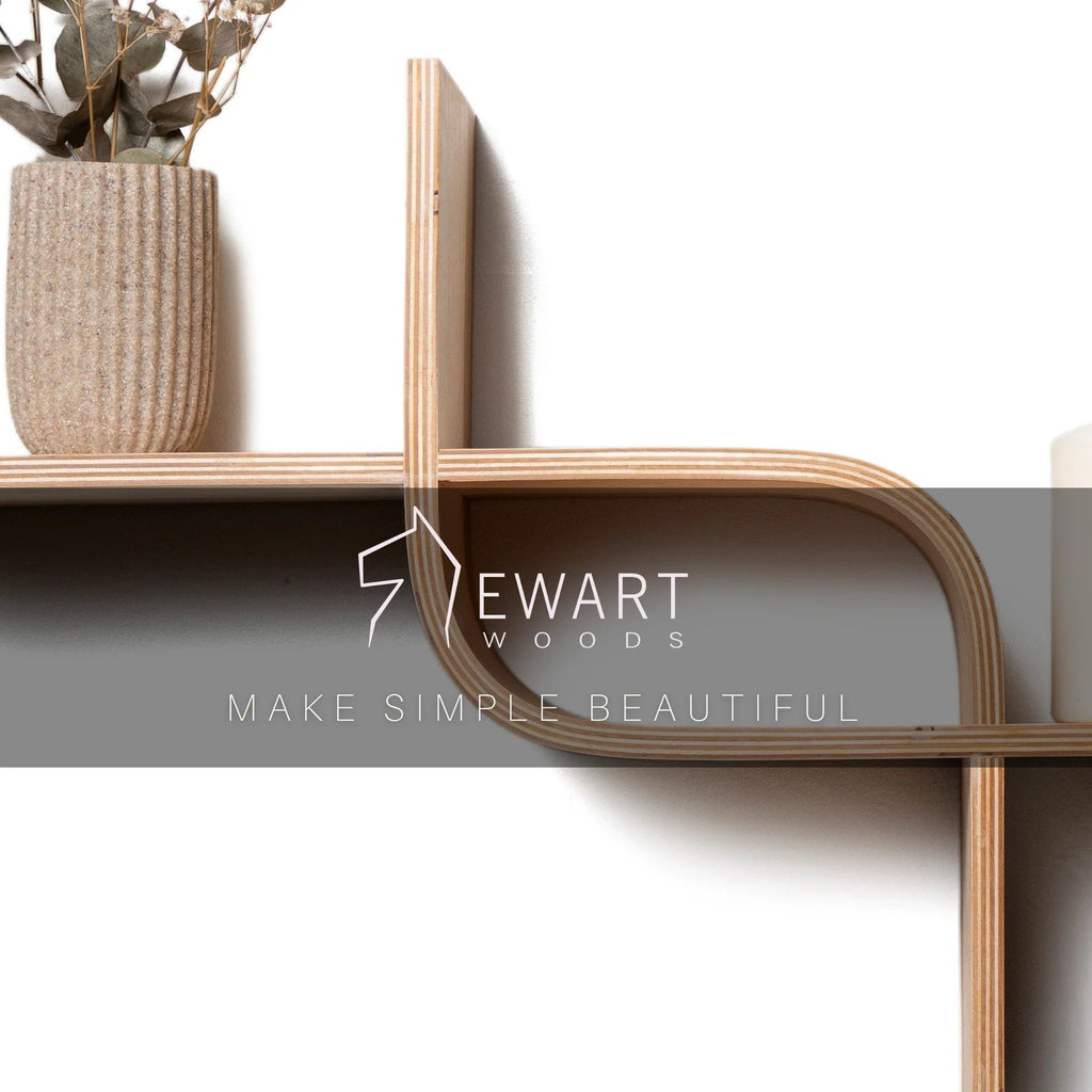 3. Close-up of Ewart Woods logo on wooden floating shelf with vase and candle, highlighting craftsmanship