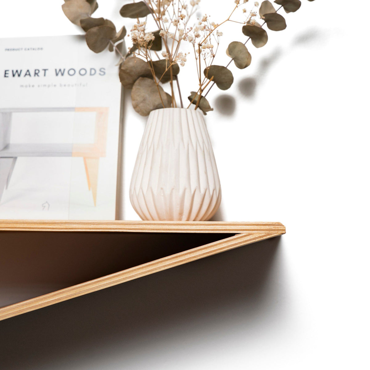 2. Close-up of ashwood floating wall shelf with a white vase and Ewart Woods catalog