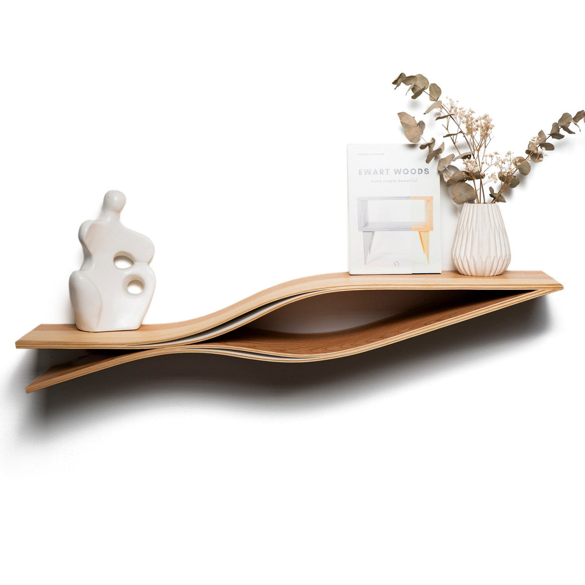 1. Handmade wooden floating wall shelf in fish shape with decorative items, including a vase and abstract sculpture, on a white wall