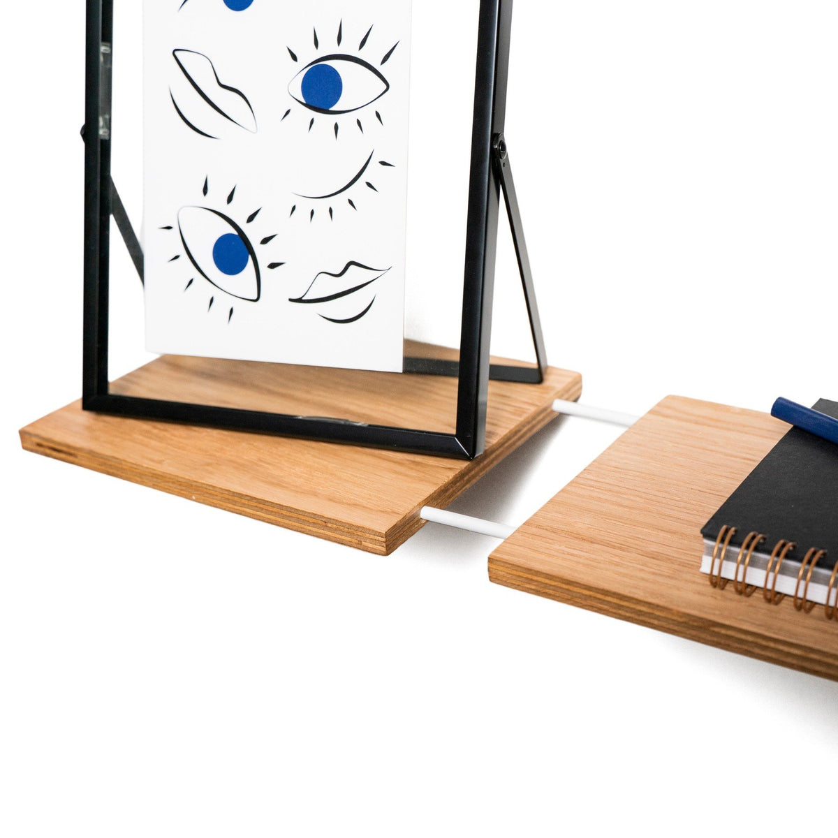 3. Close-up of wooden shelf with framed art and notebook, emphasizing functionality