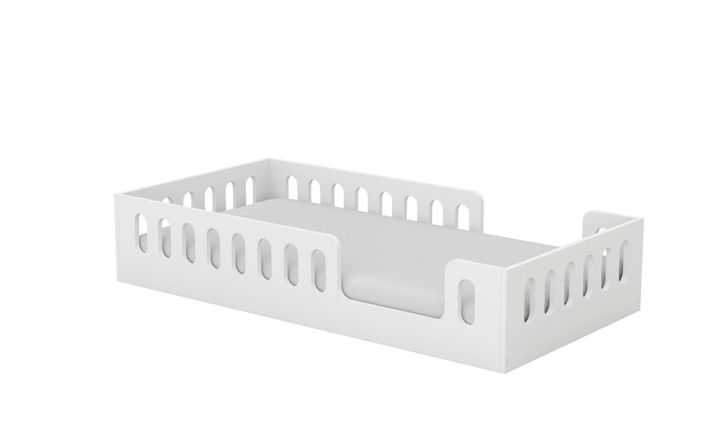 2. Angled view of white Montessori-inspired floor bed with removable fall protection