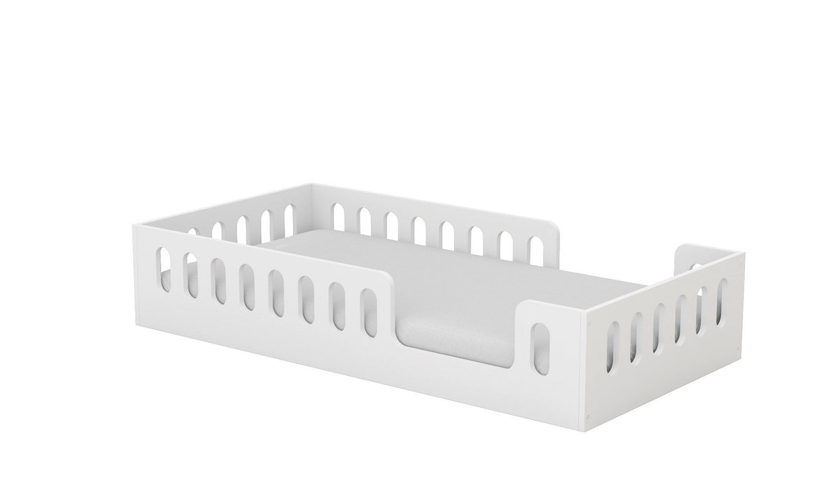 2. Angled view of white Montessori-inspired floor bed with removable fall protection