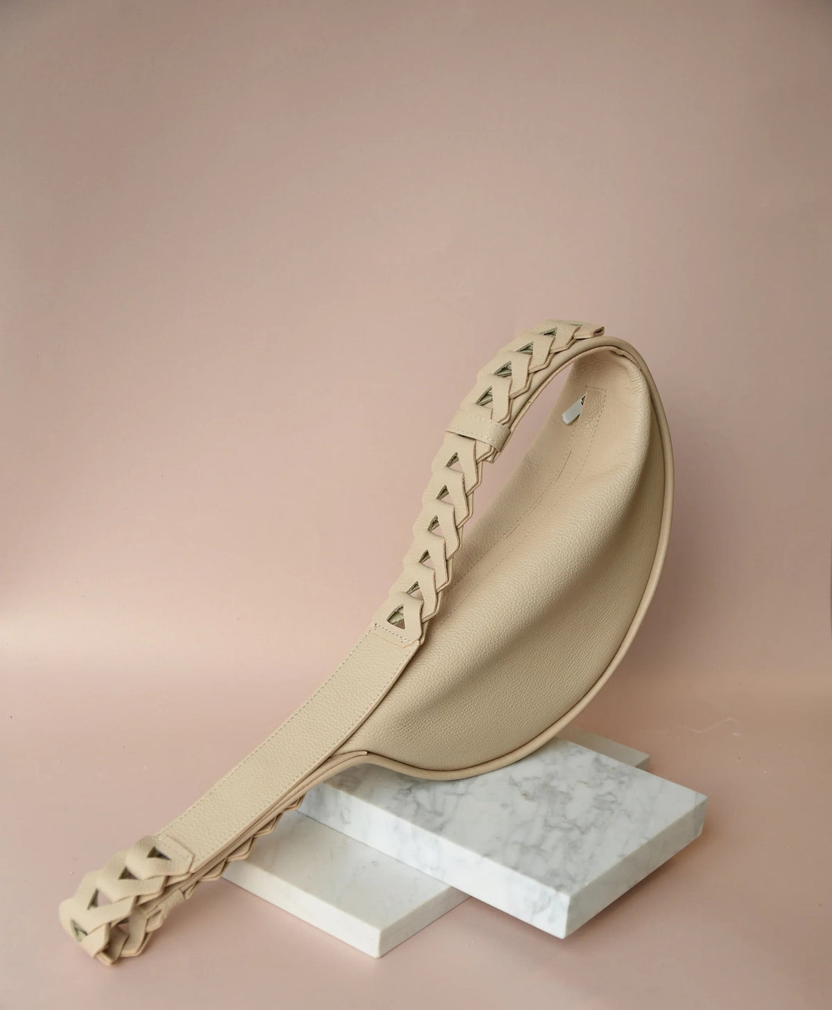2. Beige Flora Leather Bag by Gerda Retter Design displayed on marble blocks in studio setting