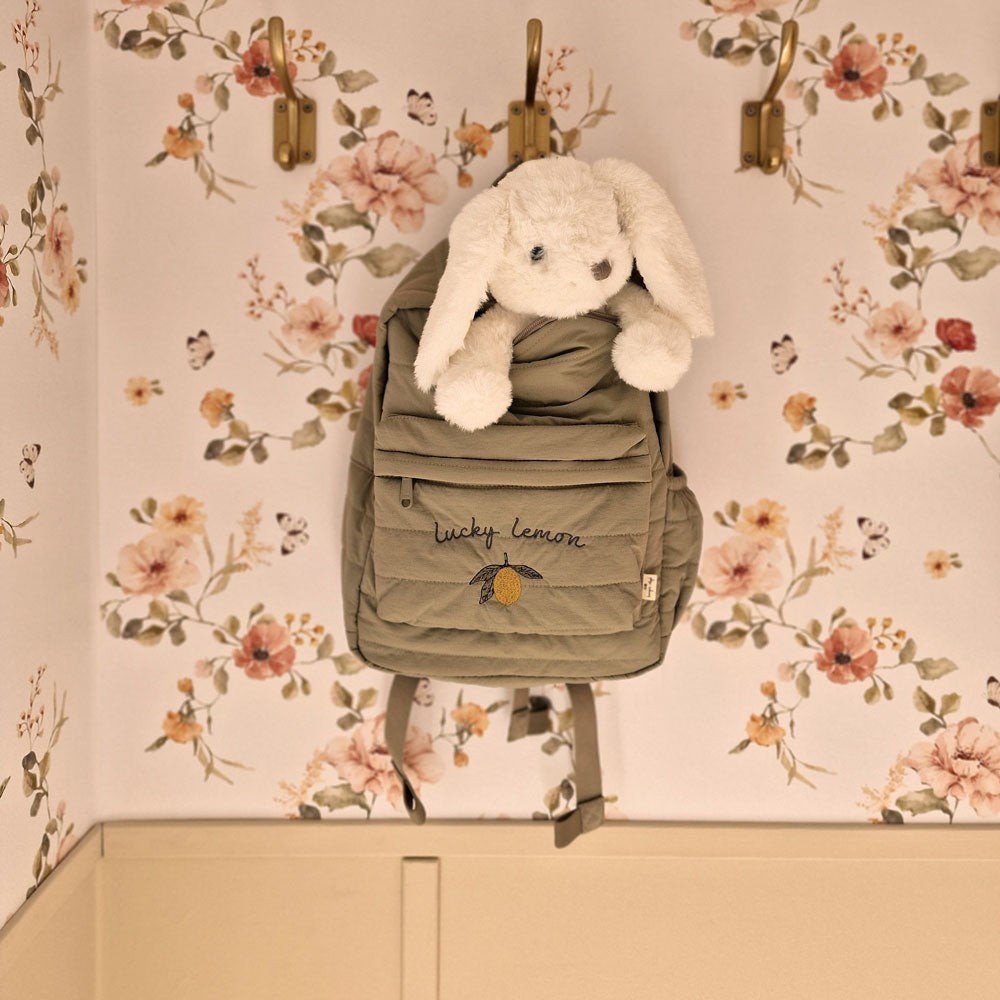 4. Close-up of floral vintage wallpaper with hanging backpack and plush toy