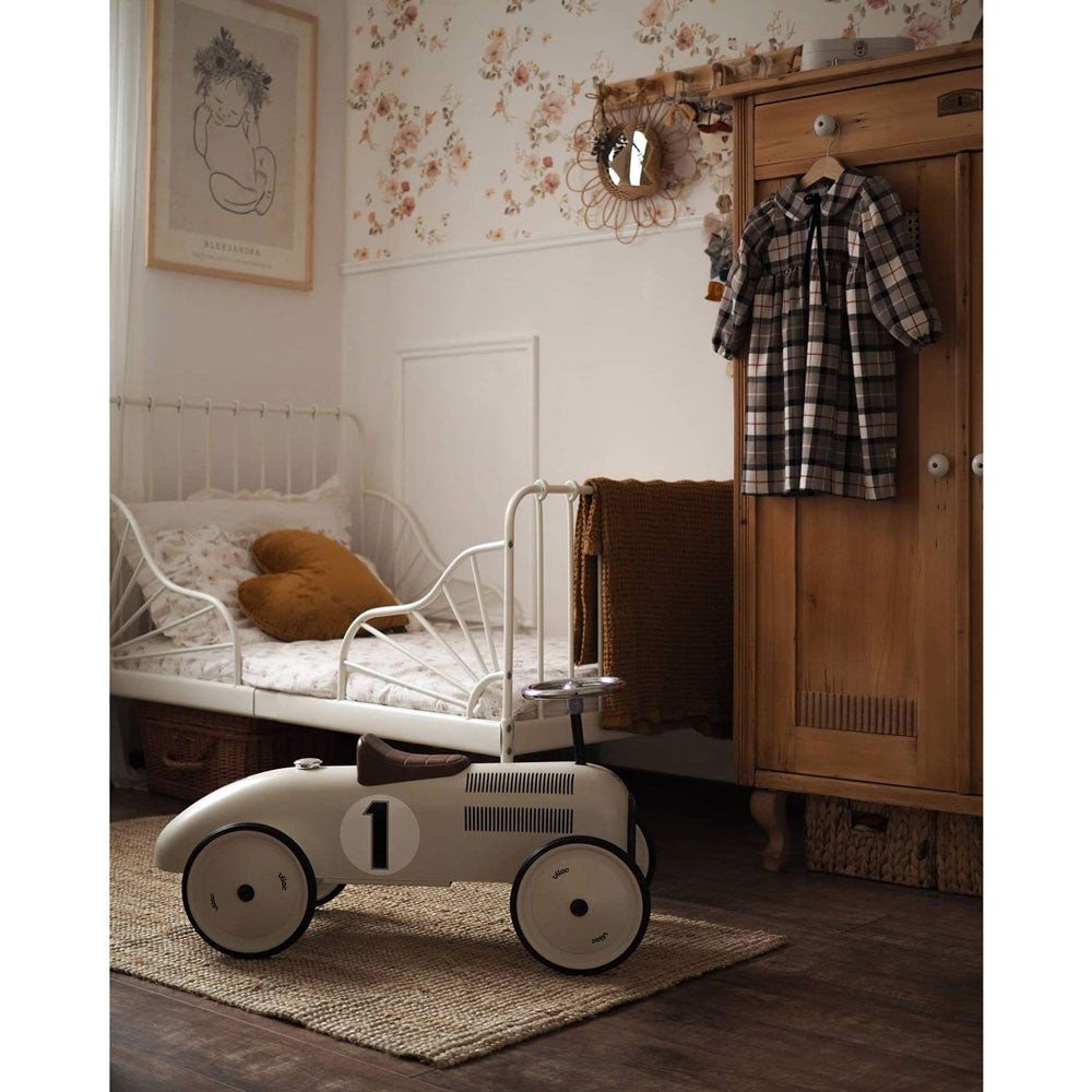 6. Vintage-themed children's room with floral wallpaper, wooden wardrobe, and toy car