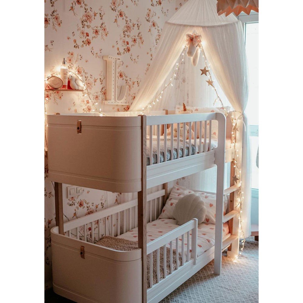 7. Bunk bed with canopy and fairy lights against floral vintage wallpaper in cozy children's room