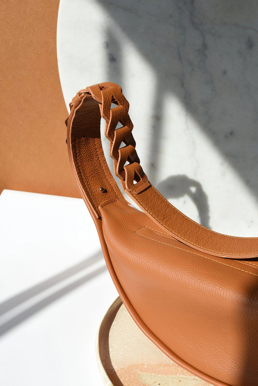4. Close-up of caramel brown Flora Leather Bag by Gerda Retter Design, highlighting braided strap detail