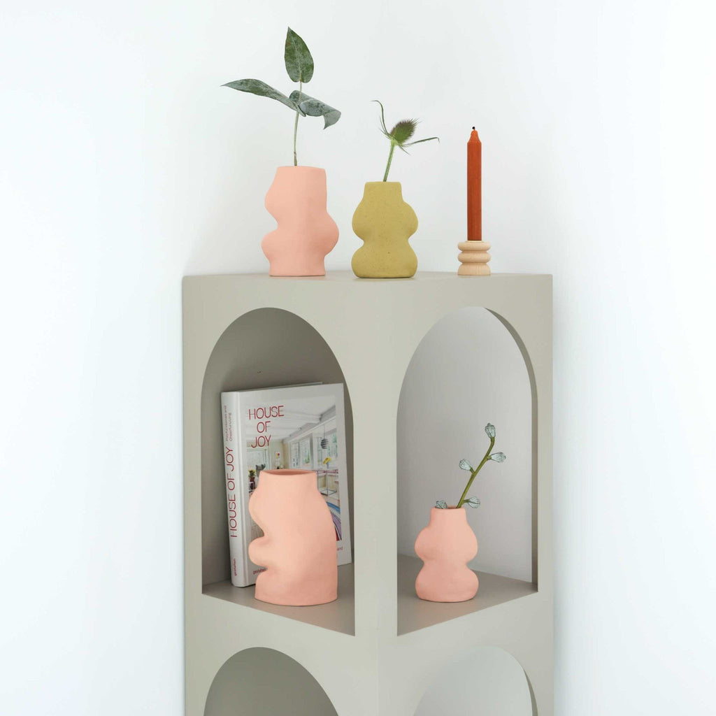 2. Collection of Fluxo Ceramic Vases in pink and yellow by 5mm Paper, styled on a modern shelf with books and candles