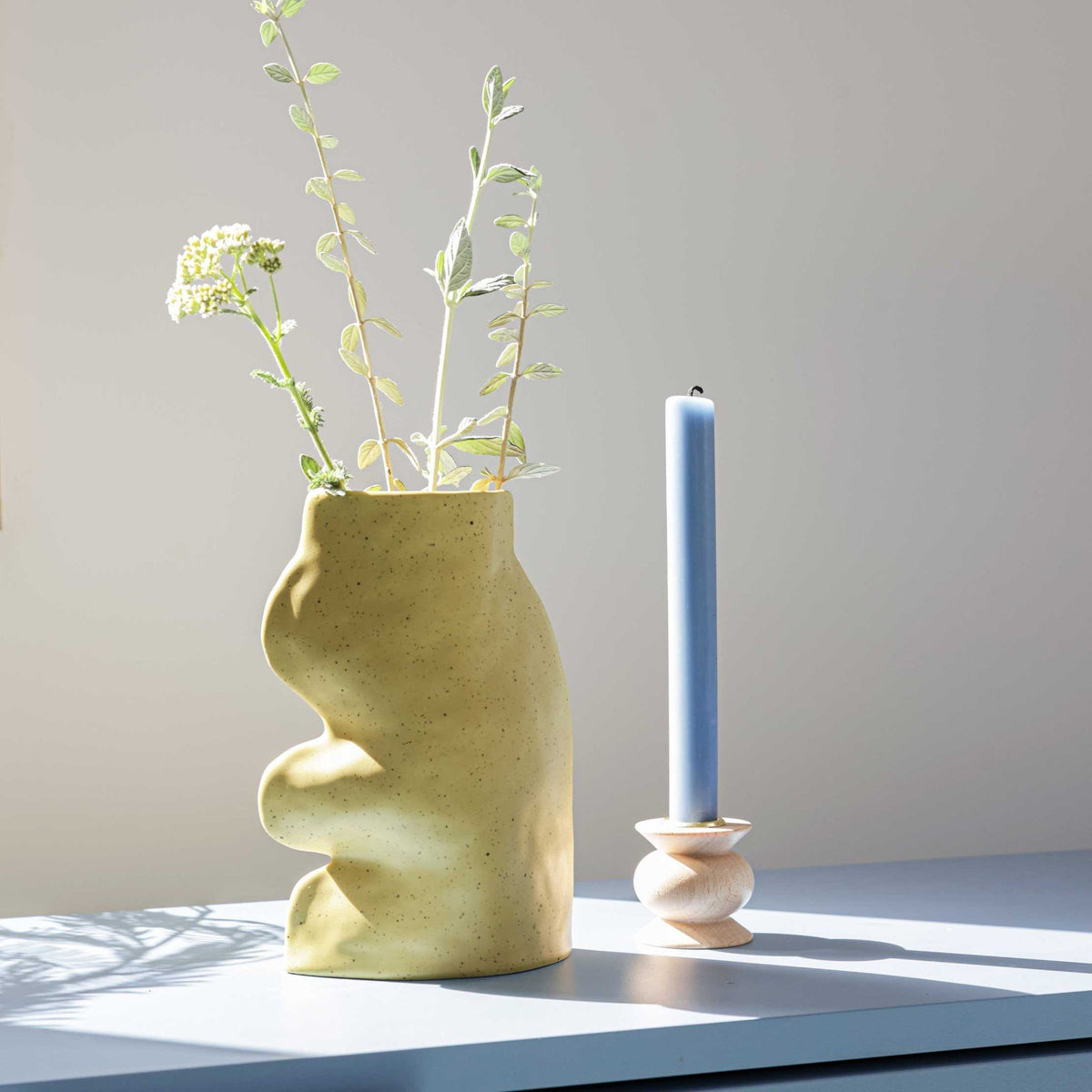 1. Fluxo Ceramic Vase Large in Pistachio by 5mm Paper, styled with flowers and candle on a table in natural light