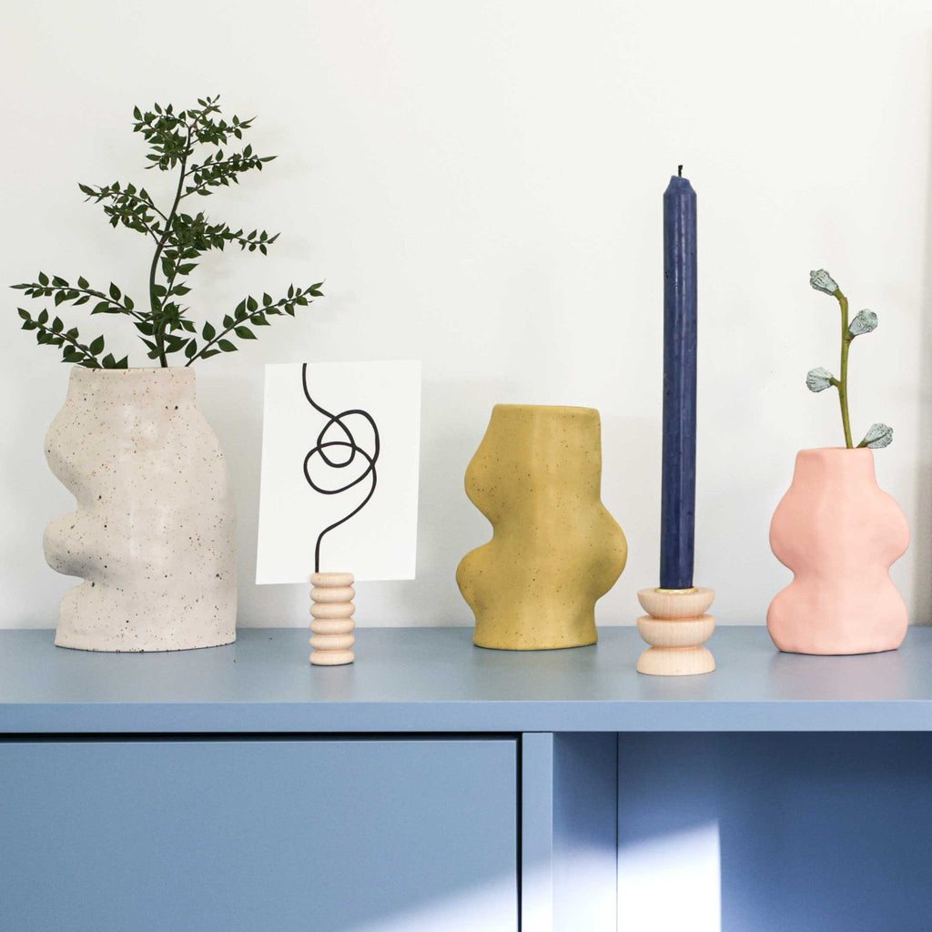 3. Collection of Fluxo Ceramic Vases in various colors, including Pistachio, on a blue cabinet