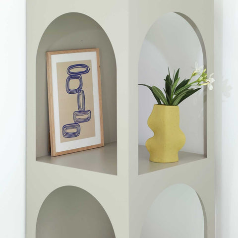 2. Fluxo Ceramic Vase in Pistachio displayed on a shelf with artwork, showcasing modern design