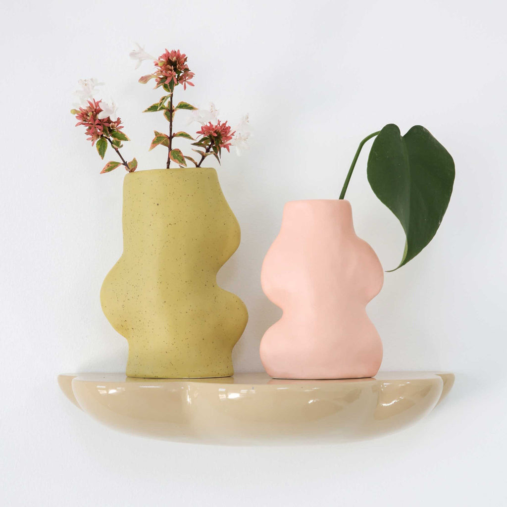 4. Pistachio and pink Fluxo Ceramic Vases on a wall shelf, each with floral arrangements