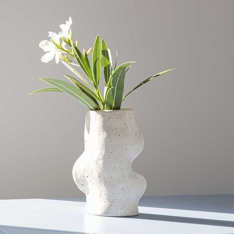 1. Fluxo Ceramic Vase in white with flowers, showcasing unique flowing lines, handcrafted in Portugal