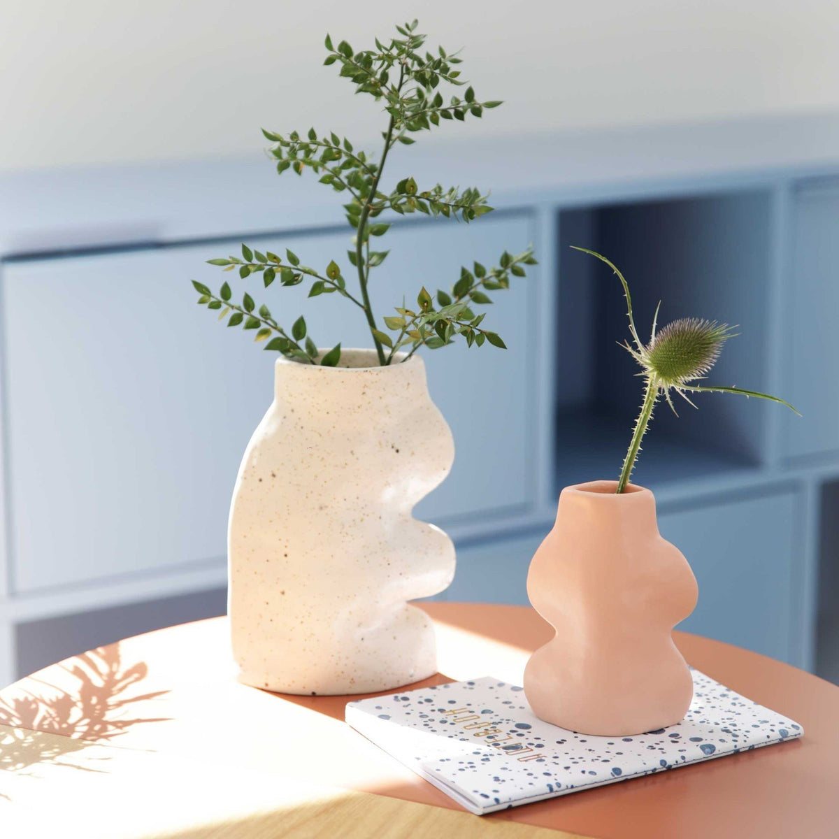 4. Fluxo Ceramic Vase Small in pink by 5mm Paper on a table with a plant, emphasizing its artisanal feel