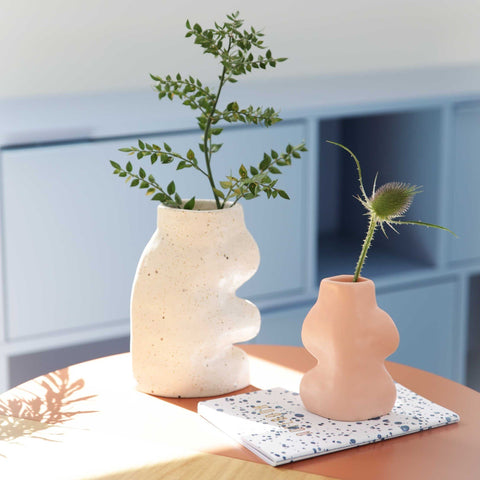 4. Fluxo Ceramic Vase Small in pink by 5mm Paper on a table with a plant, emphasizing its artisanal feel