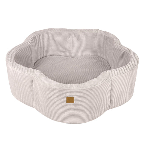 4. Ecru flower-shaped foam baby ball pit with ribbed texture and brown brand patch, shown empty in studio setting