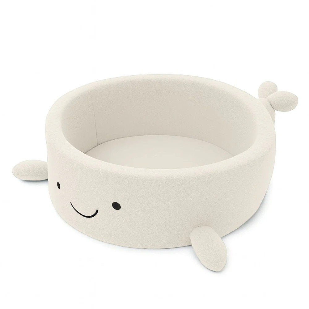 2. Cream boucle whale-shaped baby ball pit with soft fins and a smiling face, shown empty, ideal for sensory exploration