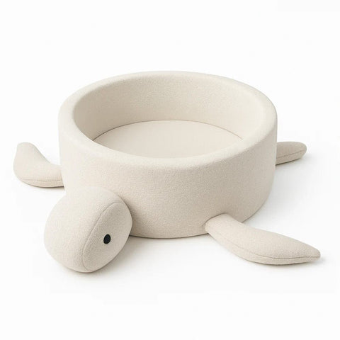 2. Turtle-shaped baby ball pit in cream beige boucle fabric with soft fins, shown in studio setting