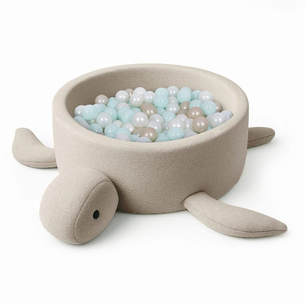 2. Beige turtle-shaped foam baby ball pit with boucle fabric, filled with pastel-colored balls, on a white background
