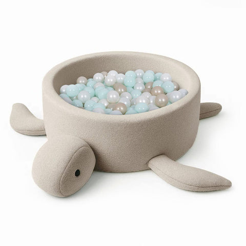 2. Beige turtle-shaped foam baby ball pit with boucle fabric, filled with pastel-colored balls, on a white background